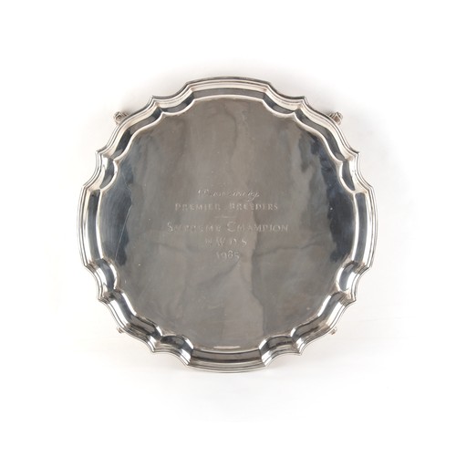 221 - Property of a lady - a George II style silver salver or waiter, with scroll feet, engraved presentat... 