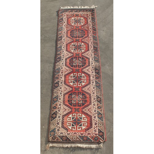 306 - Property of a deceased estate - a Persian hand-knotted wool runner, 109 by 28ins. (277 by 71cms.).