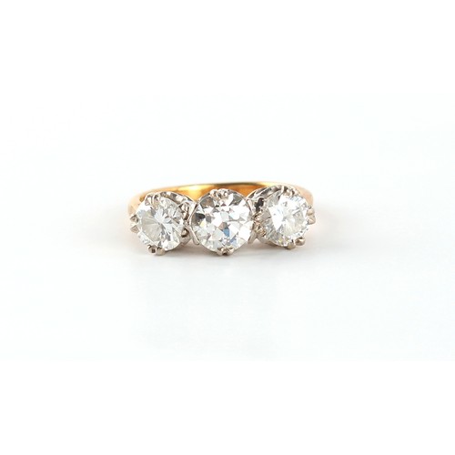 104 - Property of a lady - an 18ct yellow gold diamond three stone ring, the centre round brilliant cut di... 