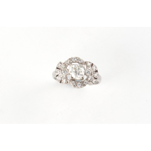 71 - An early 20th century Belle Epoque platinum diamond ring, or pierced fan & scroll form, the centre d... 