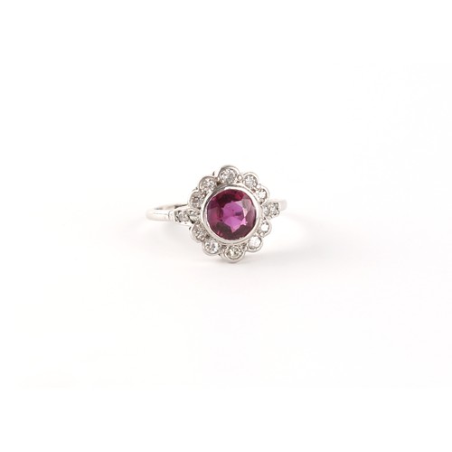 101 - An 18ct white gold ruby & diamond floral cluster ring, the certificated Thai unheated round cut ruby... 