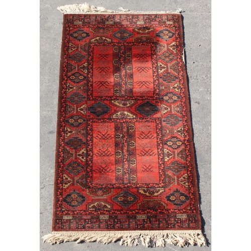 202 - Property of a deceased estate - a Turkoman design rug with red ground, slight old moth damage, 63 by... 