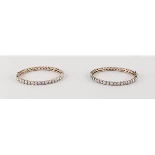 71 - A pair of diamond hinged bangles, the all round round brilliant cut diamonds each approximately 0.19... 