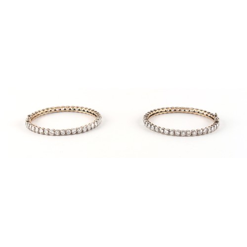 71 - A pair of diamond hinged bangles, the all round round brilliant cut diamonds each approximately 0.19... 