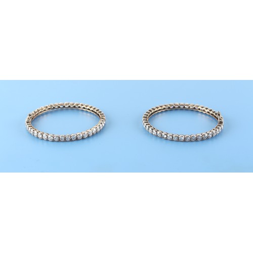 71 - A pair of diamond hinged bangles, the all round round brilliant cut diamonds each approximately 0.19... 