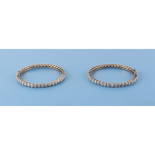 71 - A pair of diamond hinged bangles, the all round round brilliant cut diamonds each approximately 0.19... 