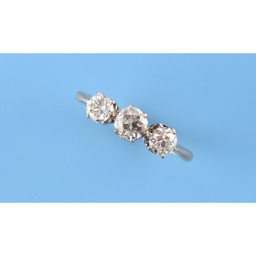 76 - An unmarked yellow gold diamond three stone ring, the round brilliant cut diamonds weighing a total ... 