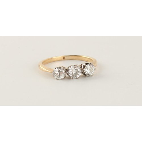 76 - An unmarked yellow gold diamond three stone ring, the round brilliant cut diamonds weighing a total ... 