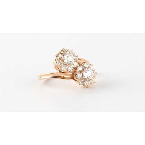 91 - An unmarked Continental yellow gold diamond twin cluster crossover ring, the estimated total diamond... 