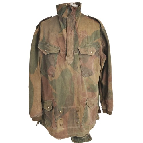 WW2 British First Pattern Paratrooper Denison Smock 1943. A large sized 7 Denison smock with intact clothing label giving maker as Hoffman & date of 1943. A broad arrowed W/I\D inspectors 'N' code also gives date of 1943. Complete with working half zip made by Lightning with intact & original tail to reverse. All brass Newey snap fasteners are fully functional. Good camouflage colours with service wear there being fraying to bottom edge in places. To rear of smock there are two stab sized lacerations which have been later patched to reverse as well a few small holes from heavy wear.