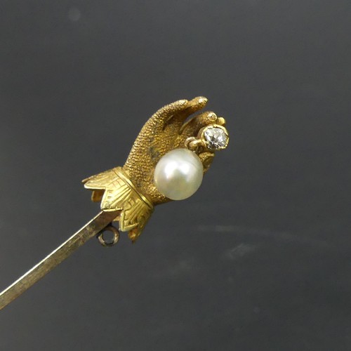 26 - Victorian gold stick pin with a diamond and pearl hand end. 2.2 grams. 72mm long (Hand 13mm).