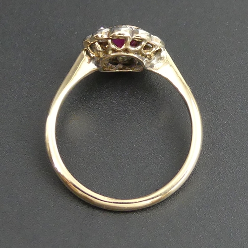 127 - 18ct gold ruby and diamond cluster ring. Size 'M'. 10.8mm top. 2.7 grams.