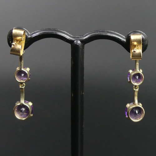 19 - A pair of 9ct gold 3 graduated amethyst drop earrings. 1.4 grams. 23mm long. Bottom stones are 5mm i... 