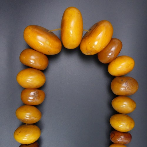 78 - African butterscotch amber copal bead necklace. 594 grams. 68 cm in length. Largest bead 6 cm.
UK Po... 