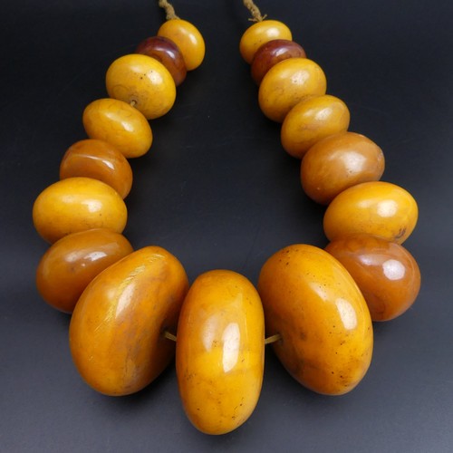 78 - African butterscotch amber copal bead necklace. 594 grams. 68 cm in length. Largest bead 6 cm.
UK Po... 