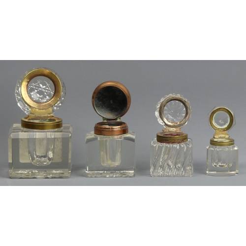 78 - Four late 19th century glass inkwells with hinged covers. Tallest 7.5 cm.  UK Postage £15.