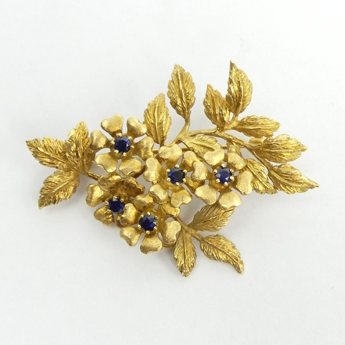 7 - 18ct gold sapphire set floral design brooch, London 1989, 16 grams. 54 x 38 mm. UK Postage £12.