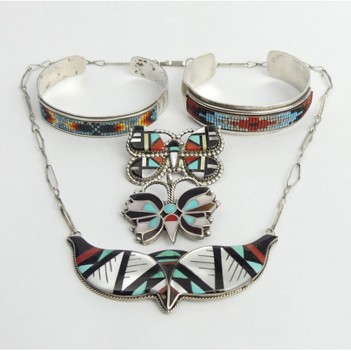 25 - Five items of Native American silver jewellery, viz. two brooch/pendants, two bangles and a necklace... 