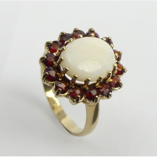 26 - 9ct gold opal and garnet cluster ring, 4.2 grams. Size N, 17.7 mm. UK Postage £12.
