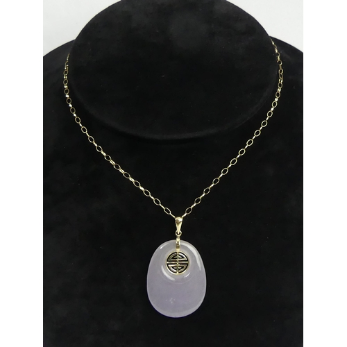 8 - 9ct gold and purple jade pendant and chain, 8.7 grams. 42 x 25 mm. UK Postage £12.