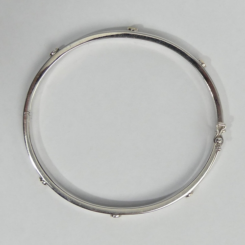 9 - 9ct white and yellow gold hinged bangle, 7.7 grams. 4.3 mm wide. UK Postage £12.