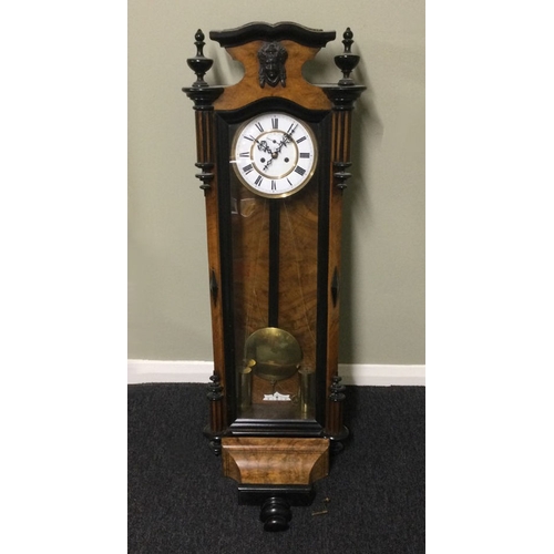 328 - A Victorian walnut and ebonised striking wall clock, complete with weights and key. 140 x 35 cm. Col... 