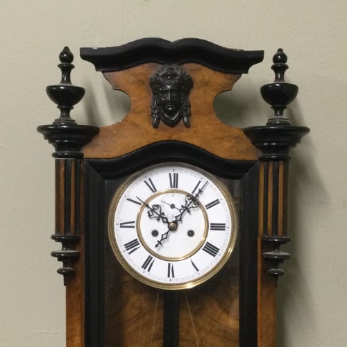 328 - A Victorian walnut and ebonised striking wall clock, complete with weights and key. 140 x 35 cm. Col... 