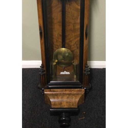 328 - A Victorian walnut and ebonised striking wall clock, complete with weights and key. 140 x 35 cm. Col... 