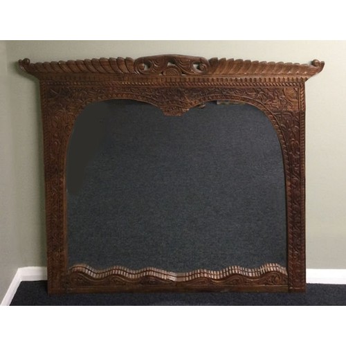 325 - A large ornately carved hardwood over mantle mirror. 152 x 121 cm. Collection only.