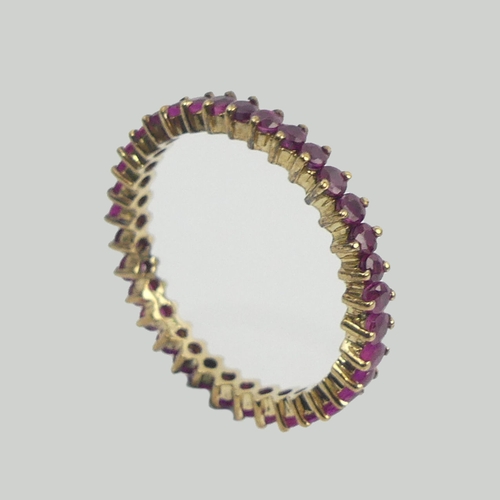 20 - 9ct gold ruby set full eternity ring, 2 grams. Size T, 3.25 mm wide. UK Postage £12.