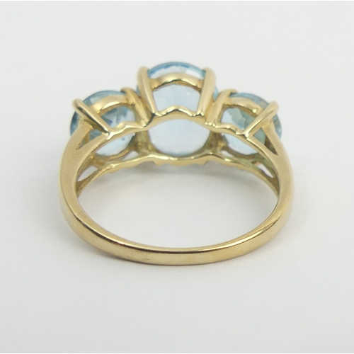 27 - 9ct gold blue topaz three stone ring, 6 grams, size T, 11.8 grams. UK Postage £12.