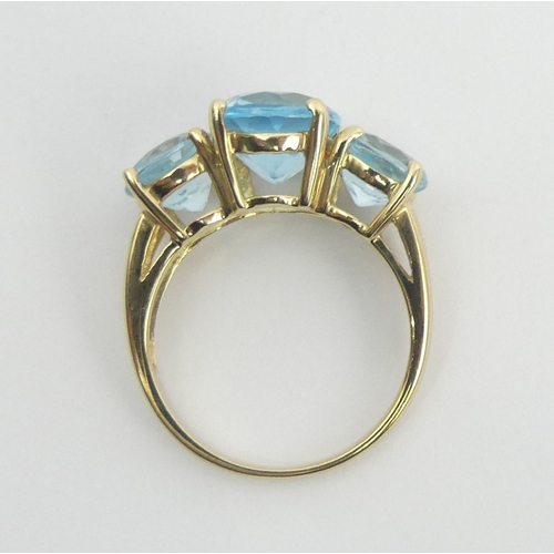 27 - 9ct gold blue topaz three stone ring, 6 grams, size T, 11.8 grams. UK Postage £12.