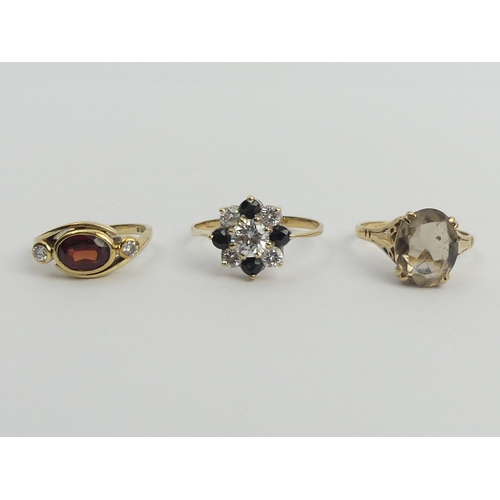 41 - 9ct gold garnet and diamond ring, 9ct gold smokey quartz ring and a 9ct gold blue and white stone ri... 