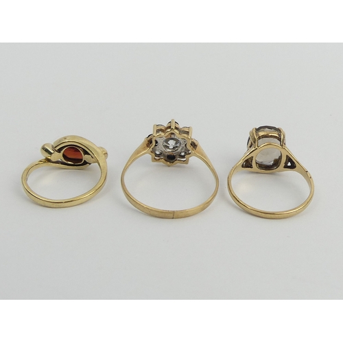 41 - 9ct gold garnet and diamond ring, 9ct gold smokey quartz ring and a 9ct gold blue and white stone ri... 
