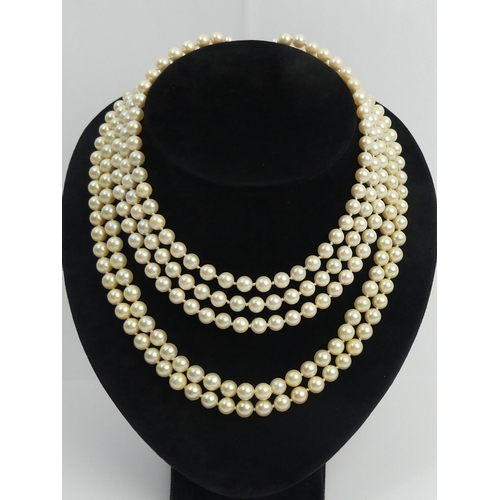 43 - A cultured pearl double strand necklace with a 9ct gold clasp and a faux pearl triple strand example... 