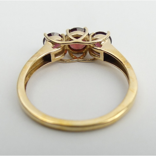 77 - 9ct gold rhodolite three stone ring, 2 grams. Size N 1/2, 5 mm wide. UK Postage £12.