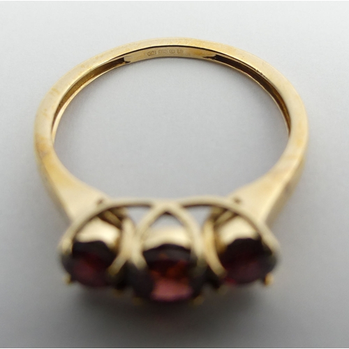 77 - 9ct gold rhodolite three stone ring, 2 grams. Size N 1/2, 5 mm wide. UK Postage £12.