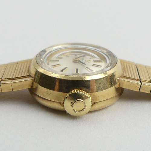 165 - Ladies 9ct gold Omega watch and strap with a manual wind movement, 28.2 grams gross. 18.5 cm x 18 mm... 