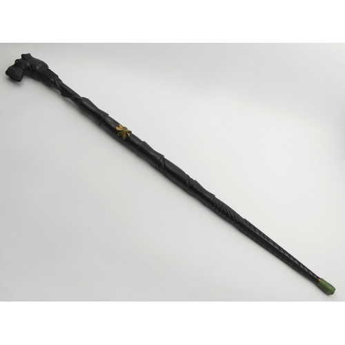 264 - An old dogs head carved ebonised walking stick. 96.5 cm. UK Postage £18.