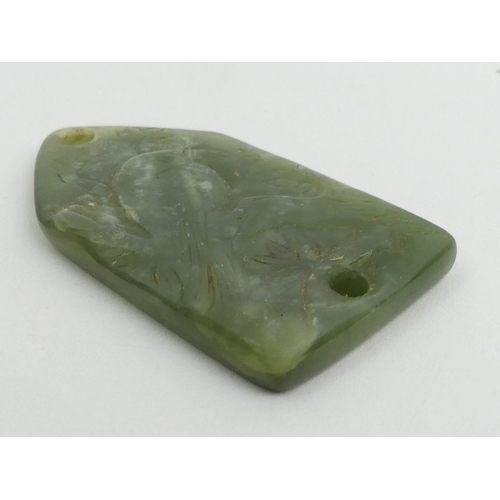 280 - Chinese jade pendant/belt fastener, carved with a bird amongst foliage. 60 x 35 mm. UK Postage £12.