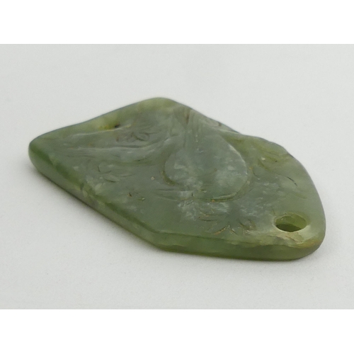 280 - Chinese jade pendant/belt fastener, carved with a bird amongst foliage. 60 x 35 mm. UK Postage £12.