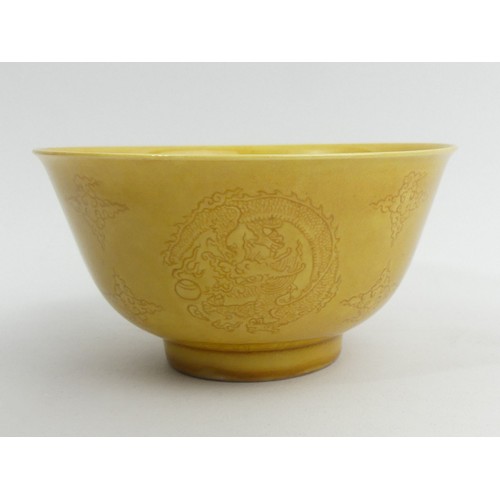 290A - Ochre glazed Chinese porcelain dragon design bowl with a six character mark. 13 x 7 cm. UK Postage £... 