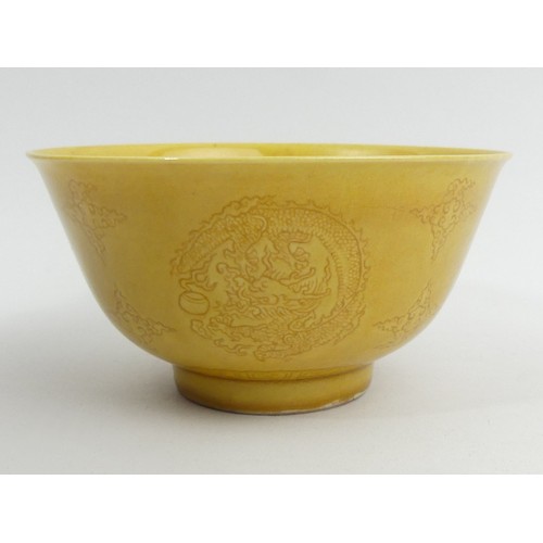 290A - Ochre glazed Chinese porcelain dragon design bowl with a six character mark. 13 x 7 cm. UK Postage £... 