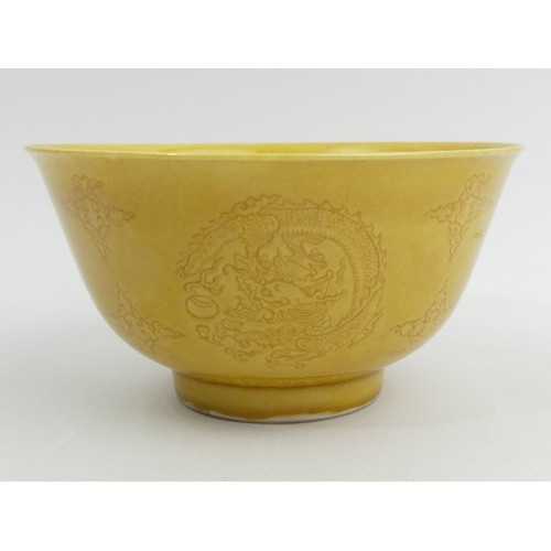 290A - Ochre glazed Chinese porcelain dragon design bowl with a six character mark. 13 x 7 cm. UK Postage £... 