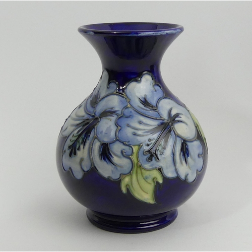 316 - Moorcroft Hibiscus design blue ground art pottery vase. 13.5 cm. UK Postage £12.