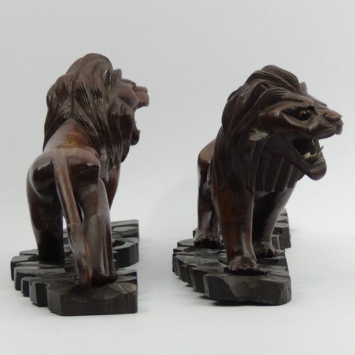 290 - A pair of early 20th century Japanese carved hardwood lions on stands. 28 cm long. UK Postage £14.