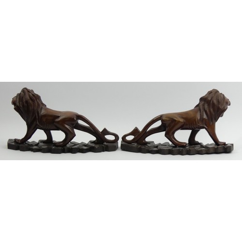 290 - A pair of early 20th century Japanese carved hardwood lions on stands. 28 cm long. UK Postage £14.