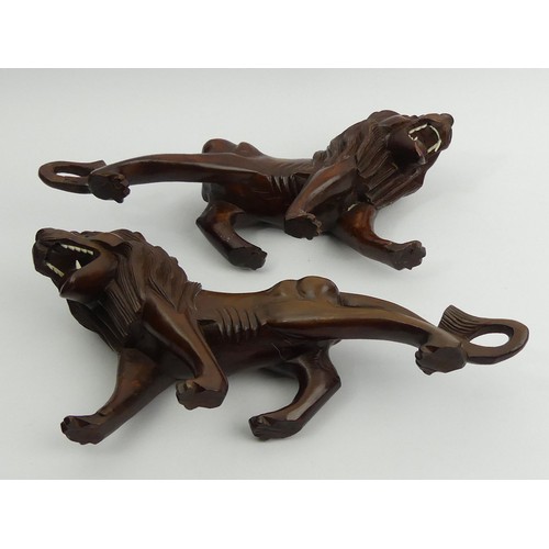 290 - A pair of early 20th century Japanese carved hardwood lions on stands. 28 cm long. UK Postage £14.