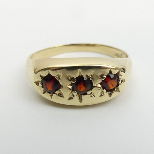 3 - 9ct gold three stone garnet ring, 3.4 grams. Size v, 9 mm. UK Postage £12.