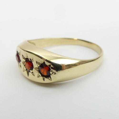 3 - 9ct gold three stone garnet ring, 3.4 grams. Size v, 9 mm. UK Postage £12.